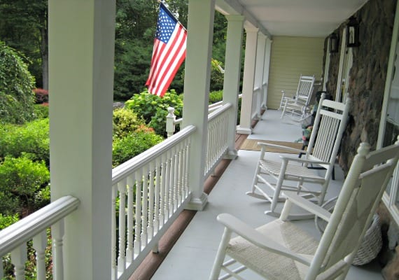 Front porch with rocking chairs and an American flag