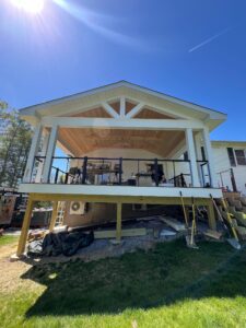 Covered porch addition, exterior view from the bottom of a hill, looking up at the addition.
